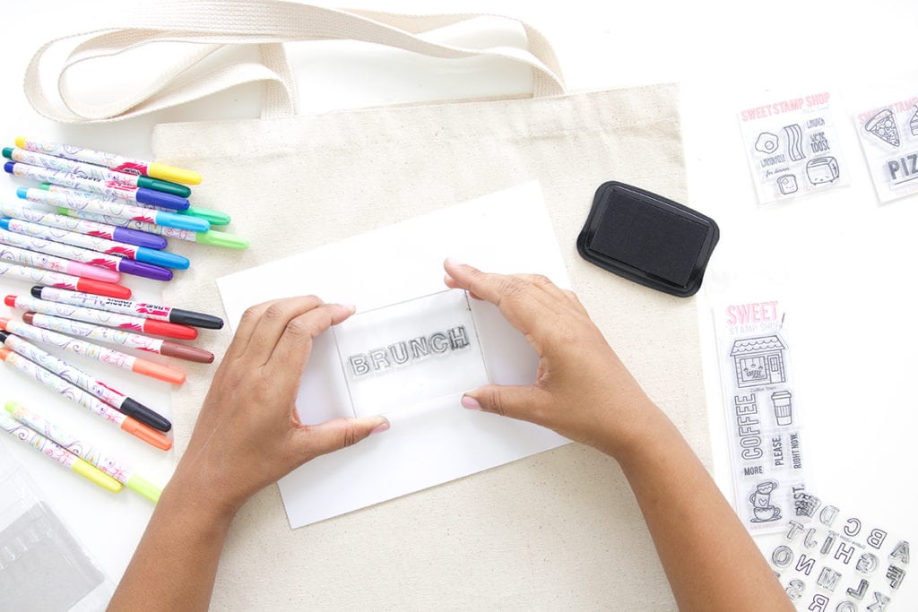 Use a few supplies to create a customized easy stamped canvas tote bag that you can color with fabric markers