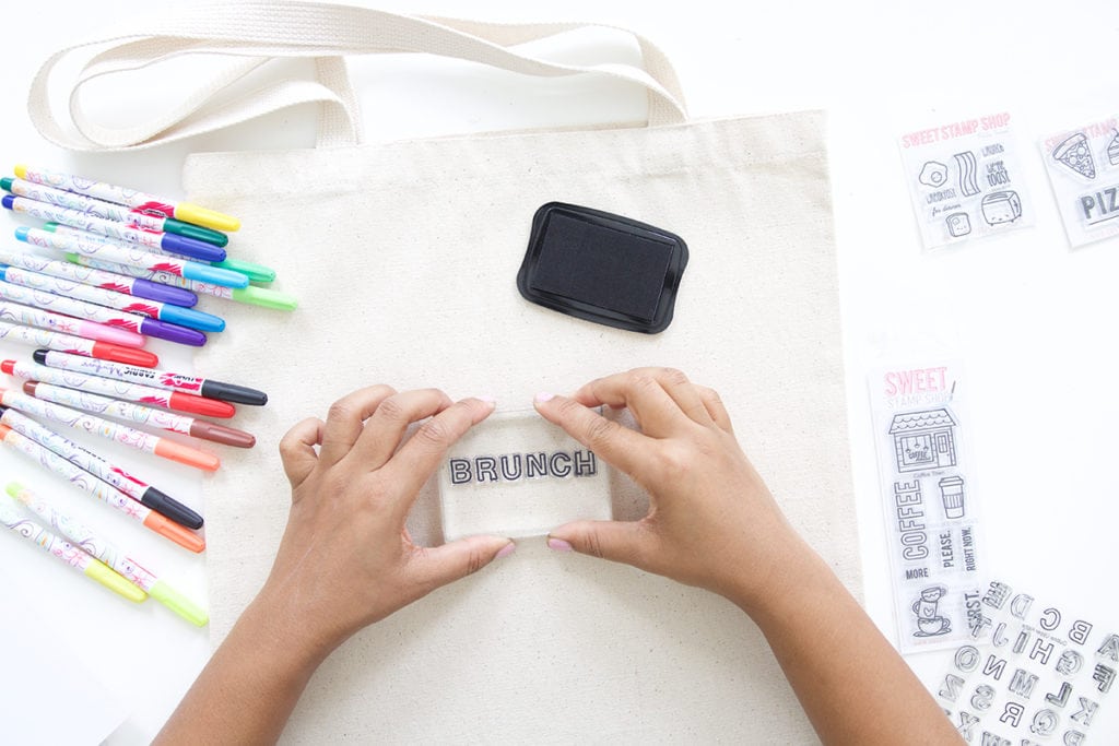 Use a few supplies to create a customized easy stamped canvas tote bag that you can color with fabric markers