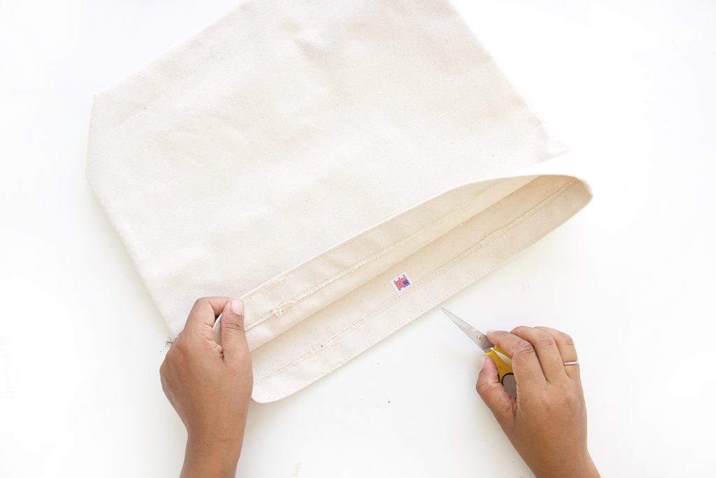 Transform a regular canvas tote bag into a DIY Leather Strap Canvas Tote Bag with the addition of leather and a few basic crafting supplies.