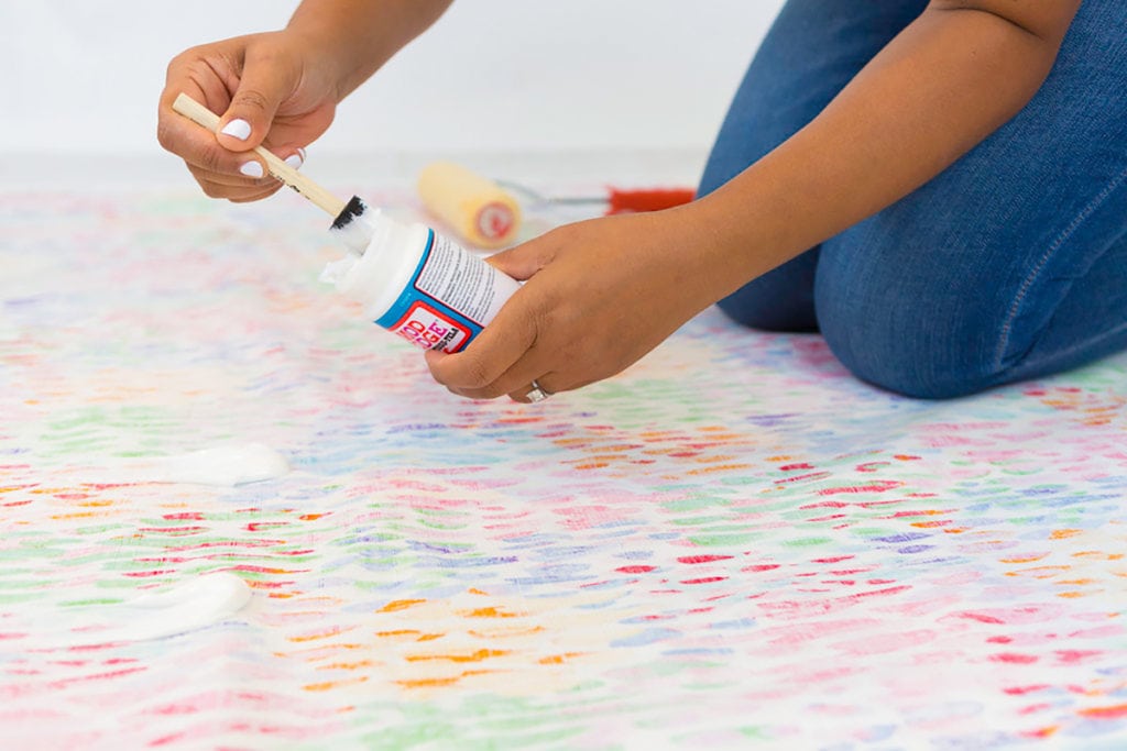 Large area rugs can be pricey! Follow this tutorial on how to turn a regular piece of fabric into a DIY Mod Podge Fabric Rug. It's totally customizable and afforable. 