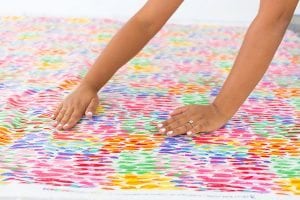Large area rugs can be pricey! Follow this tutorial on how to turn a regular piece of fabric into a DIY Mod Podge Fabric Rug. It's totally customizable and afforable.