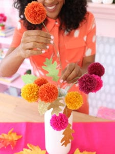 Arrange the pom pom flowers into a vase with glittery paper leaves